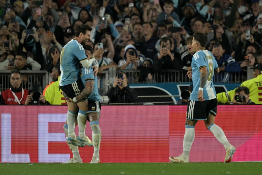 messi abrazado con sus compañeros de la seleccion festejando un gol